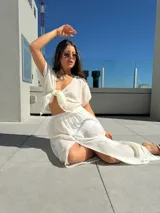 Conjunto de top negro con tirantes finos y falda larga blanca con tajo lateral.