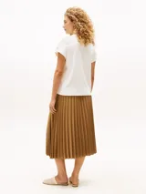 Remera blanca de algodón con cuello redondo y mangas cortas con dobladillo y botones dorados.