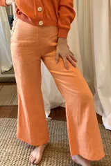 Pantalón de lino color naranja, de corte palazzo y tiro alto.