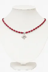 Collar corto de cuentas rojas con pelotitas de acero plateado y dije de estrella de acero plateado con circonitas.