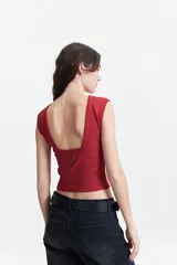 Musculosa cropped color ladrillo, de corte ajustado y espalda descubierta.