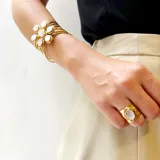 Anillo ancho de bronce con acabado martillado o texturizado, con una piedra natural ovalada engarzada en el centro.