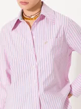 Camisa de poplin rayada rosa y celeste, de corte holgado, con cuello clásico, cierre frontal con botones y bolsillo plaqué en el pecho.