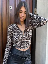 Top corto de mangas largas con estampado de leopardo y escote en V con detalle metálico.