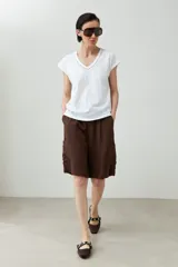 Remera color durazno con escote en V y detalle de trenza en el borde. Manga corta y corte recto.