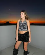 Top negro con estampado de cachemira en blanco y plateado, escote halter y espalda descubierta.