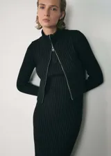 Vestido midi negro de tejido de punto en canalé, con diseño recto, cierre de cremallera en la parte delantera y cuello perkins con cierre de cremallera.