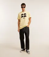 Remera color amarillo claro de algodón con cuello redondo y mangas cortas. Estampa frontal con los rostros de los integrantes de The Beatles y el logo de la banda.