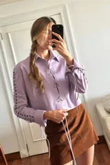 Camisa de cuero ovino color lila con cutouts en las mangas y cierre frontal con lazos.