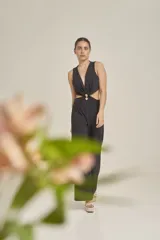 Enterito color ladrillo con escote en "V" profundo y sin mangas. Presenta aberturas en la cintura y corte palazzo.