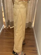 Pantalón ancho color beige, de corte holgado desde la cadera hasta el tobillo.