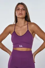 Conjunto deportivo color violeta compuesto por un top con tiras cruzadas en la espalda y un short ajustado con frunce en la parte trasera.