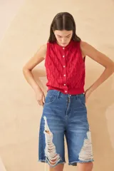 Chaleco de punto color crudo con diseño calado de corazones, sin mangas y con botones joya.