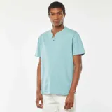 Camiseta celeste de manga corta con cuello henley y tres botones.