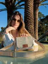 Bandolera dorada de cuero con textura tipo piel de cocodrilo, con correa larga regulable y cierre con solapa y broche imantado.