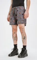Short de baño gris con estampado de calaveras, dagas y llamas en tonos naranja y negro.