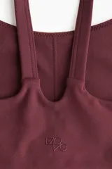 Top deportivo color borgoña, confeccionado en tejido funcional con SoftMove™ y DryMove™. Diseño de breteles con escote redondo y copas forradas con relleno extraíble.