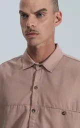 Camisa manga larga rosa con bolsillo con ojal y botón en delantero, de calce oversize confeccionada en textil plano fresco y liviano.