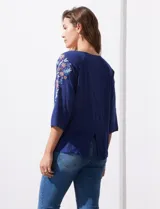 Blusa azul con escote redondo, mangas 3/4 con bordado floral y abertura central con botones. Marca Forgotten Grace.