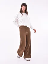 Pantalón negro de corte ancho y tiro alto, con cordón ajustable en la cintura.