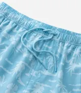 Bermuda de baño masculina de microfibra, color celeste claro, con estampado repetitivo en blanco de palmeras y paisaje tropical. Presenta cintura elástica con cordón ajustable blanco y bolsillos laterales.