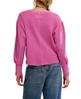 Buzo blanco de algodón con escote a la base, hombros caídos y mangas amplias con detalle de ojalillos y cordones en los puños.