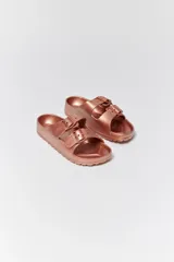 Sandalias de goma color rosa metalizado, con dos correas ajustables con hebilla.