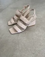 Sandalia de tacón bajo color beige, fabricada en cuero vacuno con tiras.