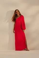 Vestido largo rojo de un solo hombro, con manga larga abullonada y tajo lateral.
