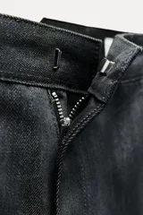 Pantalón de jean azul oscuro, de tiro medio, corte wide leg y bolsillos laterales.