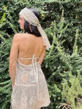 Vestido corto con lentejuelas color verde esmeralda, escote en V profundo y espalda descubierta.