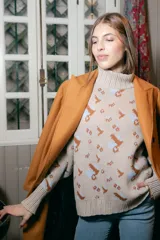 Sweater beige con cuello alto y estampado de anclas en gris.