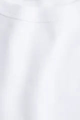 Remera blanca de algodón con cuello redondo ribeteado acanalado y mangas cortas.