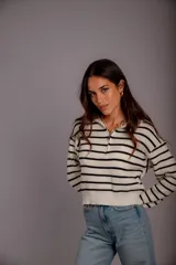 Sweater de punto color beige con rayas horizontales blancas, cuello polo con cierre de cremallera y mangas largas.