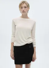 Sweater de punto fino color beige, con cuello redondo y mangas largas.