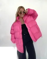 Campera puffer verde, de corte oversize, con cuello alto y cierre frontal con botones a presión y cremallera.