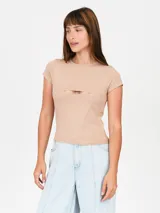 Remera color beige con escote cut-out en el pecho y mangas cortas.