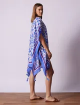 Kimono tejido color naranja con estampado geométrico en blanco y celeste, y terminación con borlas.