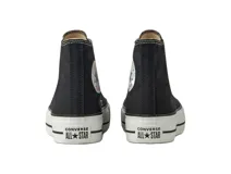 Zapatillas de lona de caña alta color negro con suela doble, parche de estrella en el tobillo y placa "All Star" en el talón.