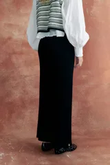 Pantalón negro de tejido de punto, corte recto y tiro medio.
