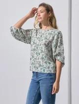 Blusa de gasa color blanco con estampado de hojas verdes, de mangas 3/4 abullonadas con puños elásticos.