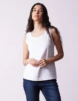 Blusa blanca sin mangas de seda fría, con cuello redondo y apliques de flores blancas.