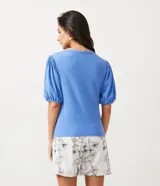 Blusa de punto texturizado color celeste, con cuello redondo y mangas cortas abullonadas.