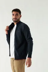 Campera tejida azul marino con cuello alto, cierre frontal y puños acanalados con detalle de línea roja.