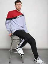 Buzo Umbro a la base con cortes y cambios de color: rojo, gris y negro. Logotipo Umbro estampado en el pecho.