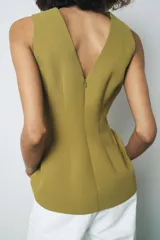 Top color verde oliva, sin mangas, con escote en V tanto en la parte delantera como en la espalda y corte peplum en la cintura.