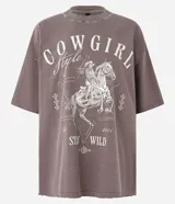 Remera color marrón con efecto lavado, de corte holgado y mangas cortas. Estampa frontal con diseño de una cowgirl a caballo y texto "Cowgirl Style Stay Wild".