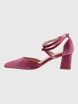 Zapato de tacón de terciopelo color borgoña, con punta fina y tiras cruzadas en el empeine que se atan al tobillo.