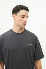 Remera blanca de manga corta con estampado en la espalda con texto en gris y diseño floral.