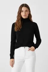 Polera de manga larga color negro, cuello alto tipo polera y calce ajustado al cuerpo.